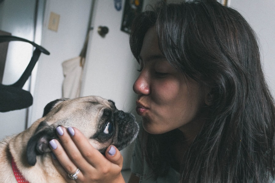 A person holding a pug close to their face.